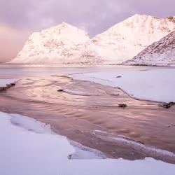 Water streams on beach full of snow