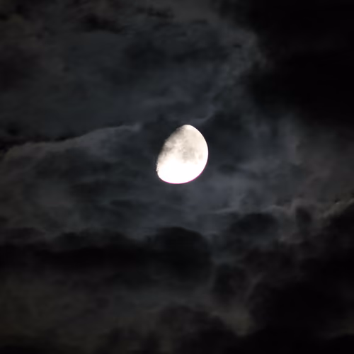 Beautiful moon among the clouds, on a black sky, view from Ukraine