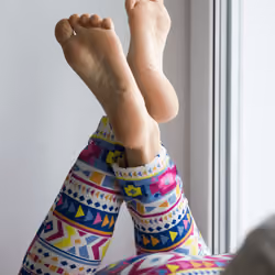 Sexy and beautiful female soles and feet crossed on windowsill