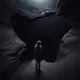 A person standing at the edge of a dark abyss